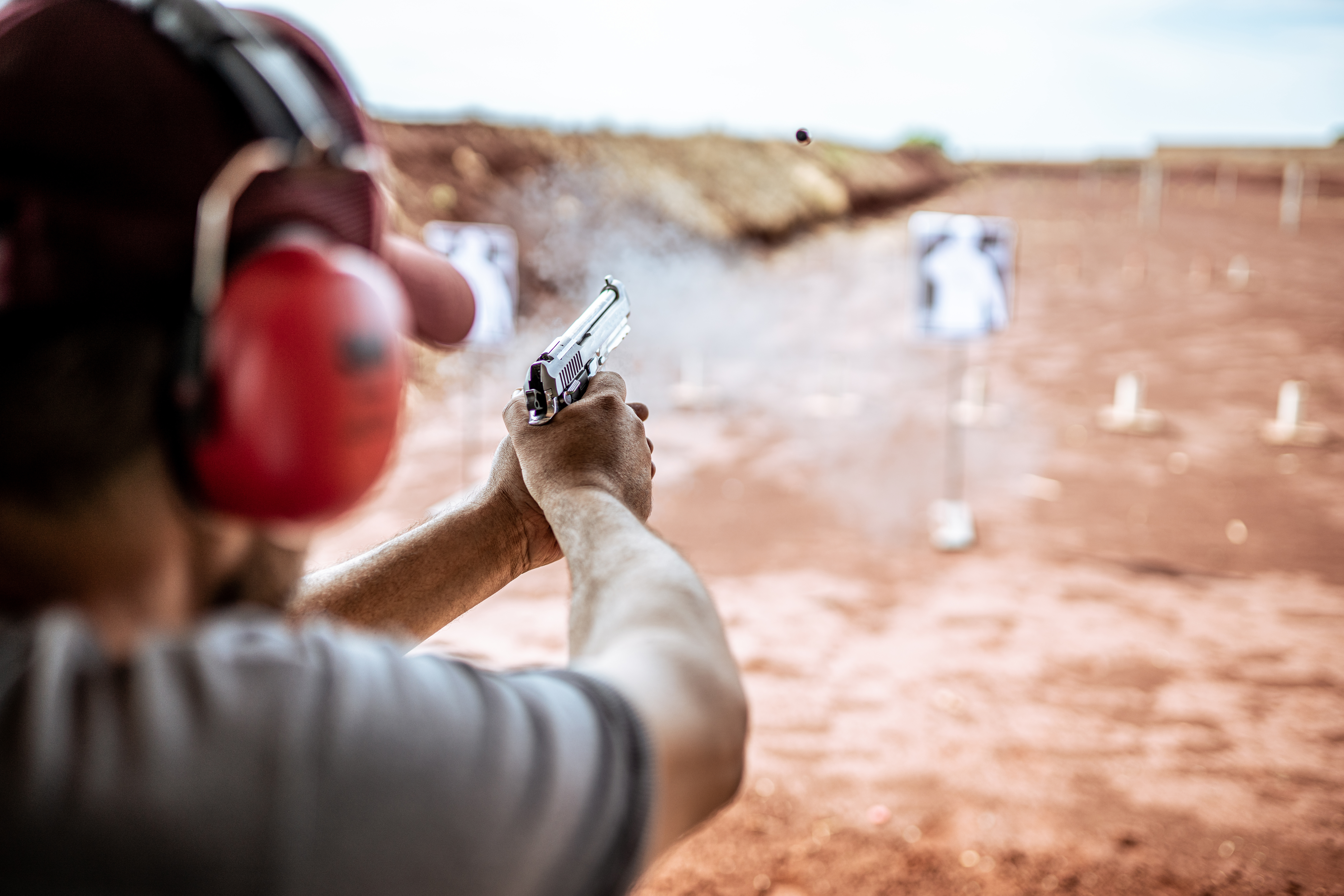A man is holding a gun and aiming it.